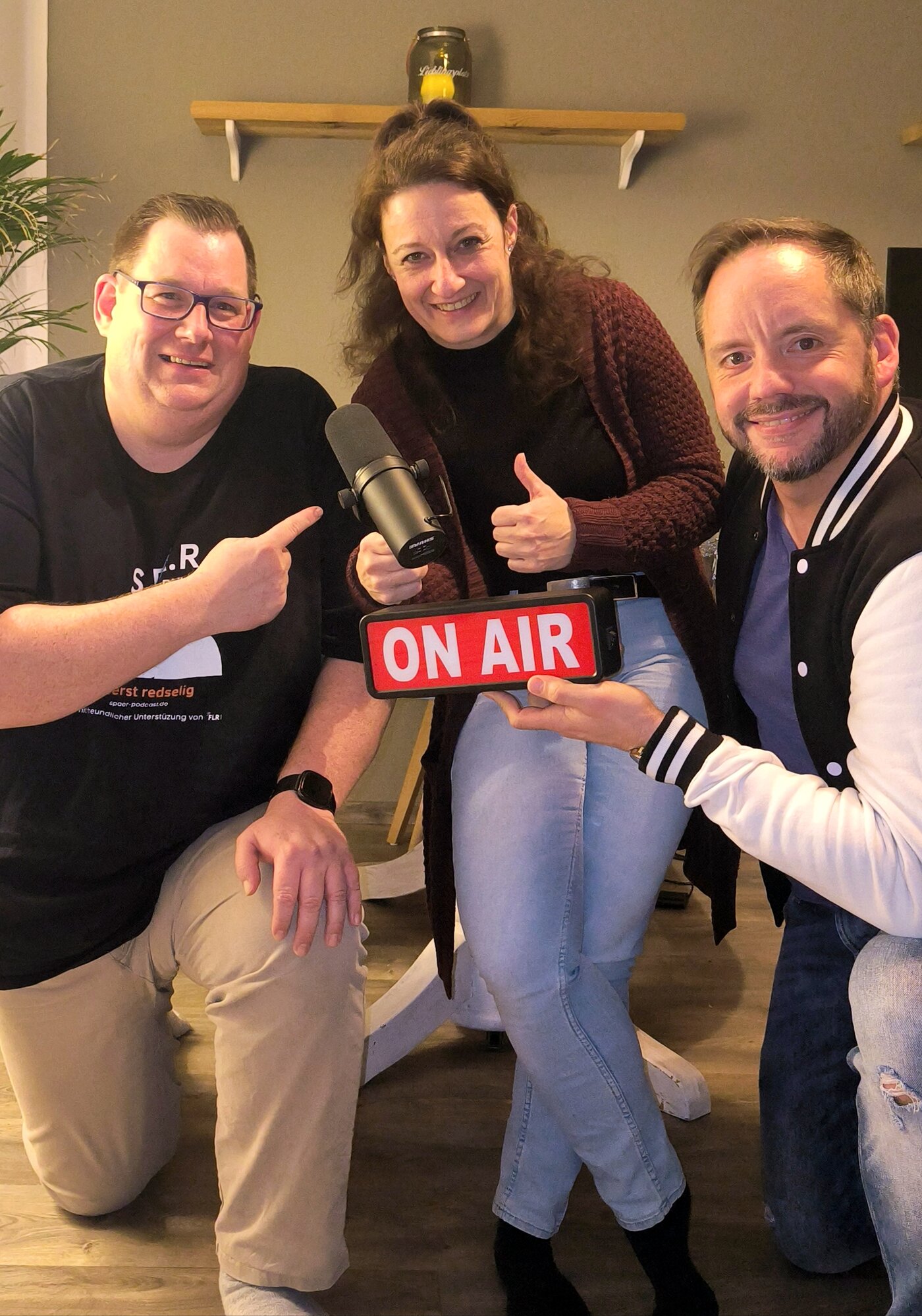 Sascha, Ina Hoinkis und Pjär sitzen gemeinsam im SPÄR-Setup und halten das On-Air-Schild in die Kamera.